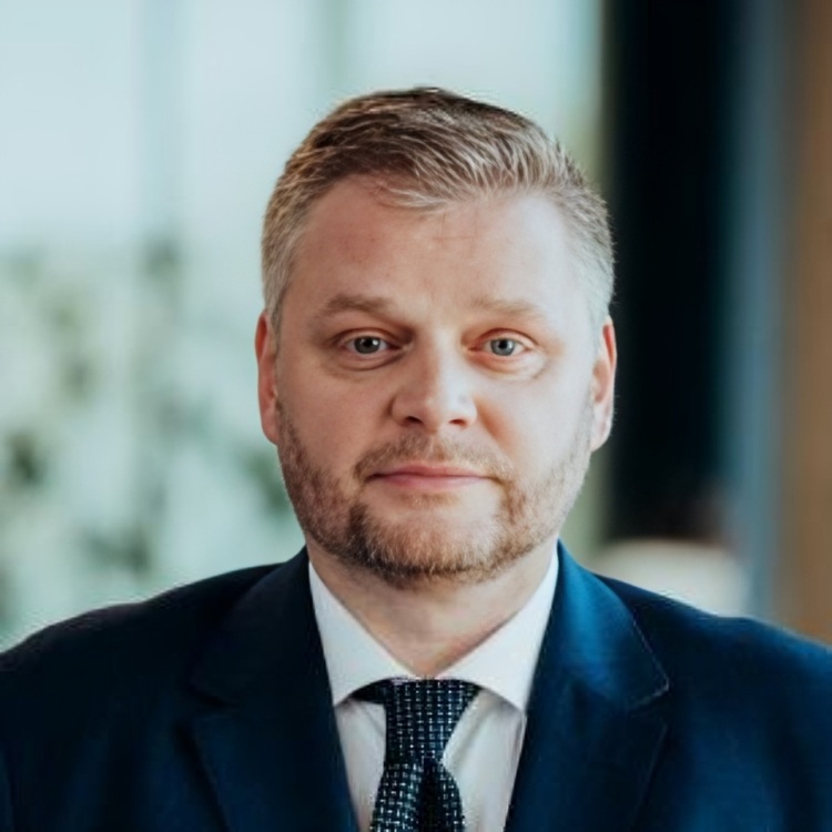 Twarz Kamila Sikory, mężczyzna w garniturze.